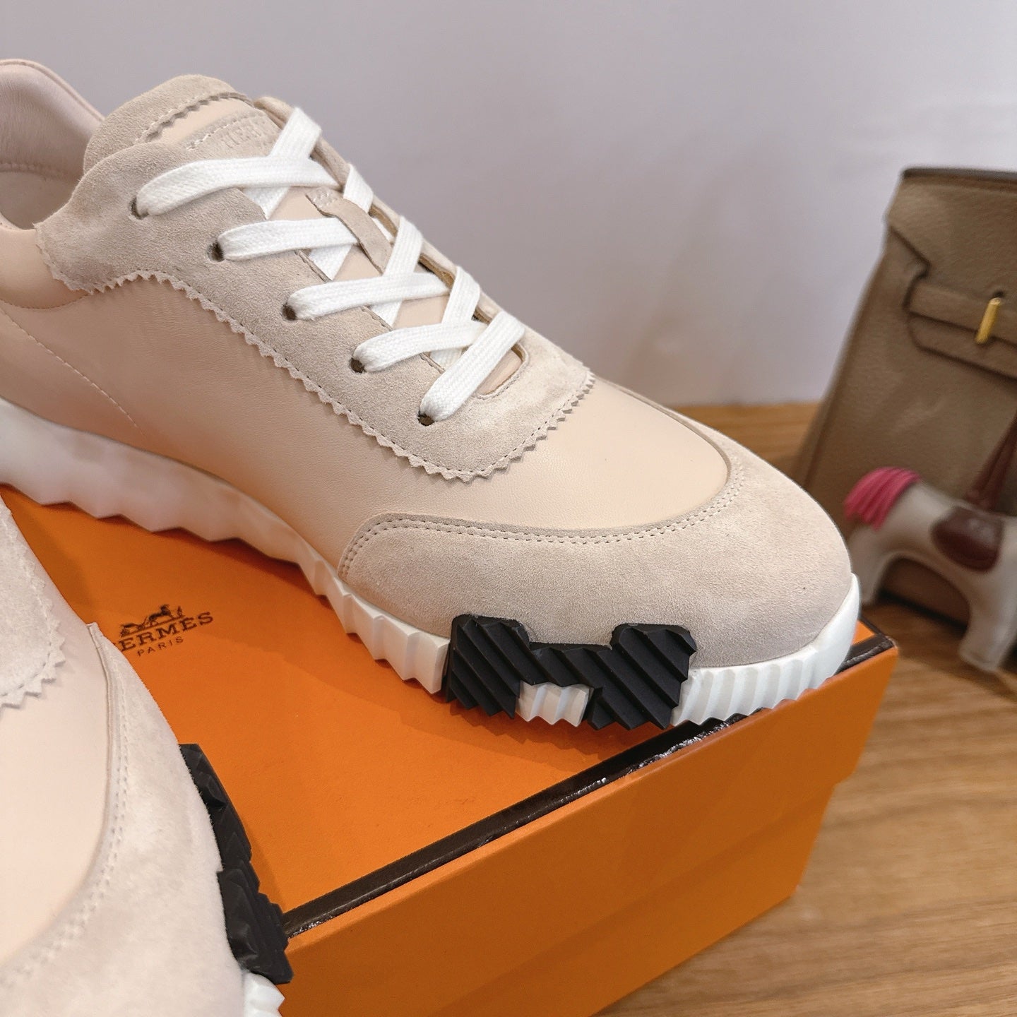 Unisex beige sneaker upper with white laces and black-and-white sole tread