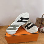 Hermes unisex sneakers outsole view, light gray suede with white rubber tread and stripes