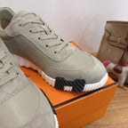 Hermes unisex sneaker side view, light gray suede with lace-up and textured rubber sole
