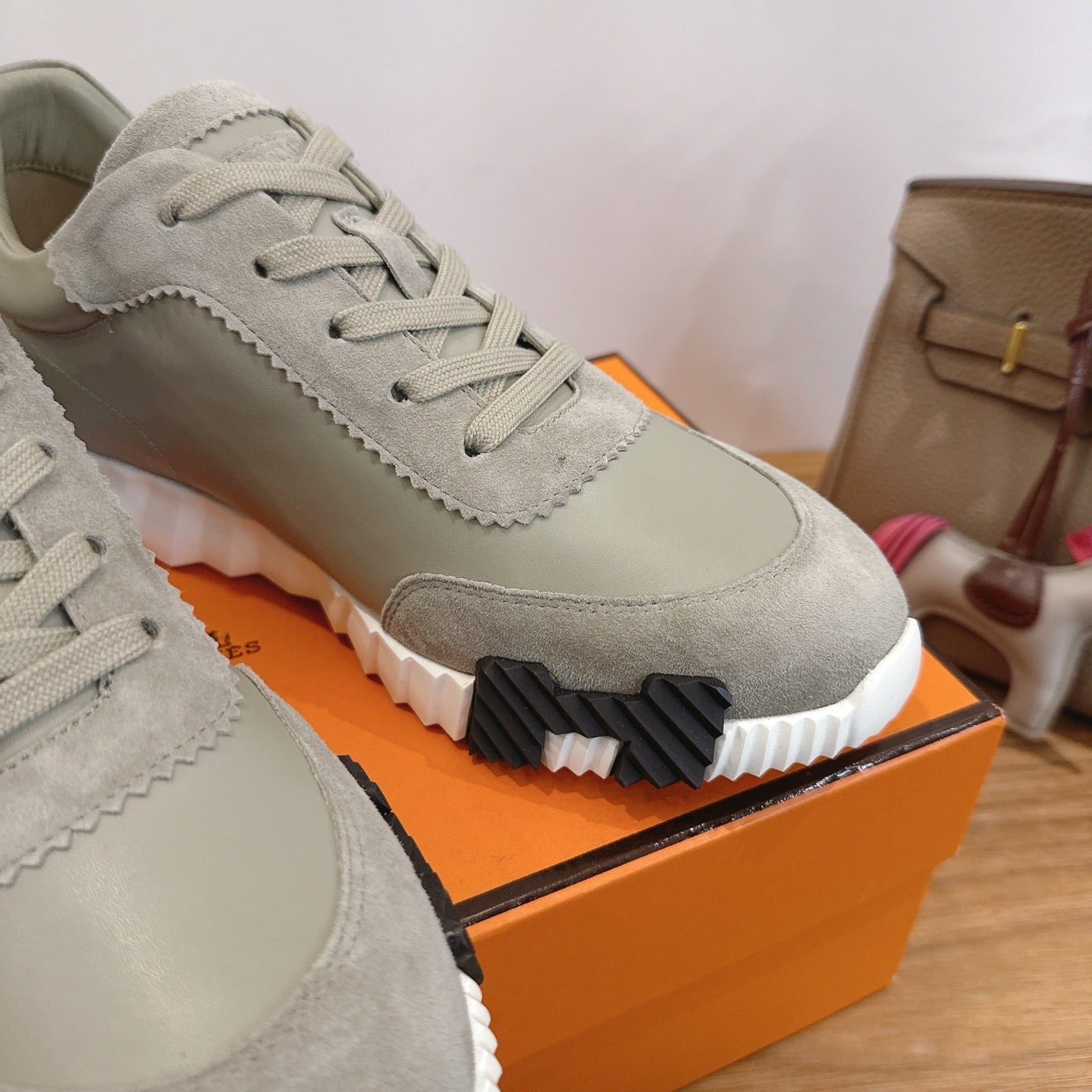 Hermes unisex sneaker side view, light gray suede with lace-up and textured rubber sole