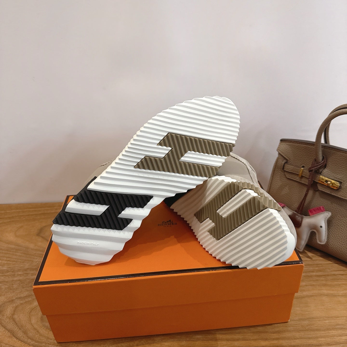 Unisex sneaker outsole view on orange box, thick tread with black accents