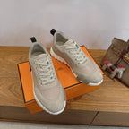 Unisex sneakers on orange box, light beige with white laces and chunky tread