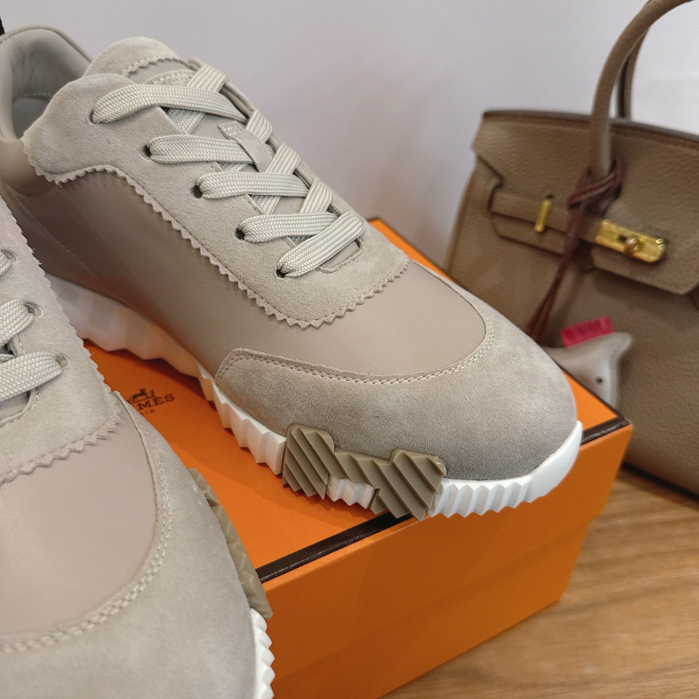 Unisex sneaker close-up: light beige suede, lace-up front, scalloped trim