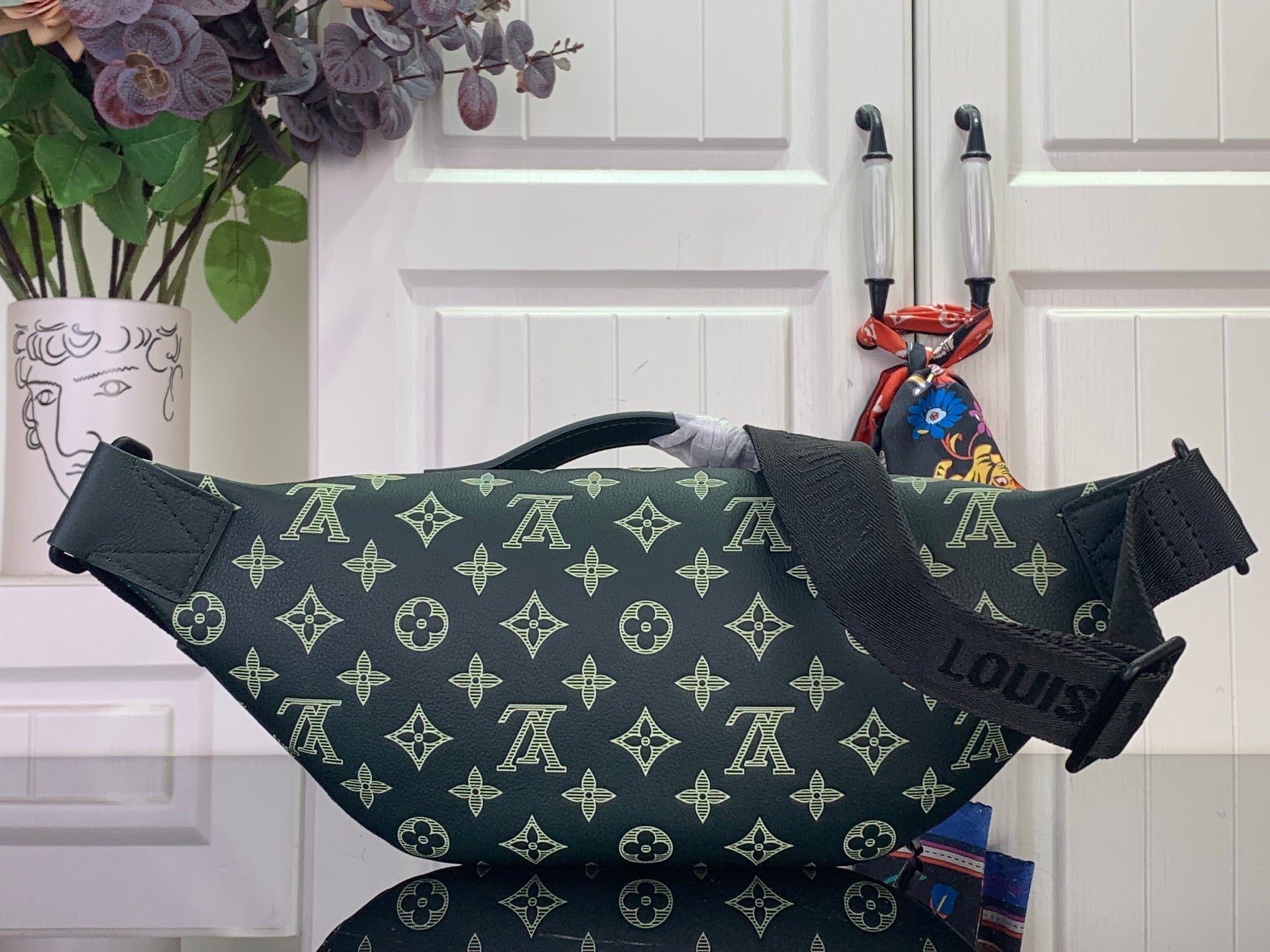 Louis Vuitton monogram bag in dark green with front zipper and strap loops