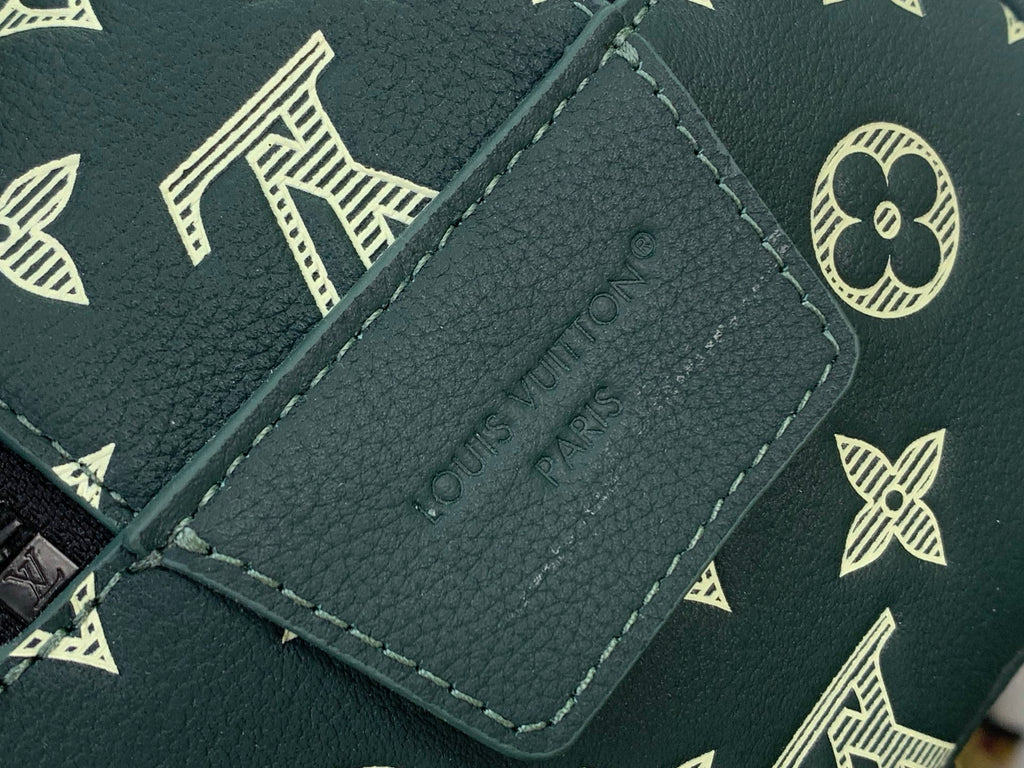 Dark green leather Louis Vuitton tag label with gold stitching detail