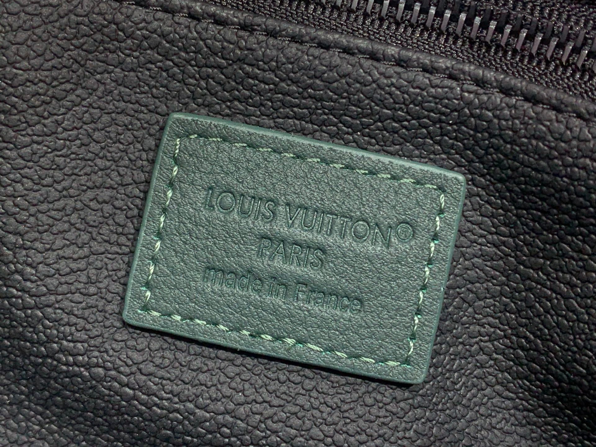 Louis Vuitton Paris label on dark green leather, stitched rectangle tag