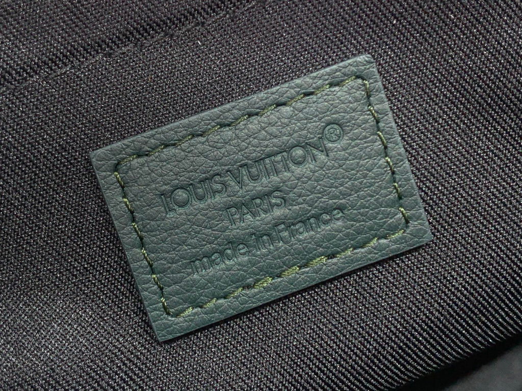 Louis Vuitton Paris leather logo patch with engraved text on dark fabric