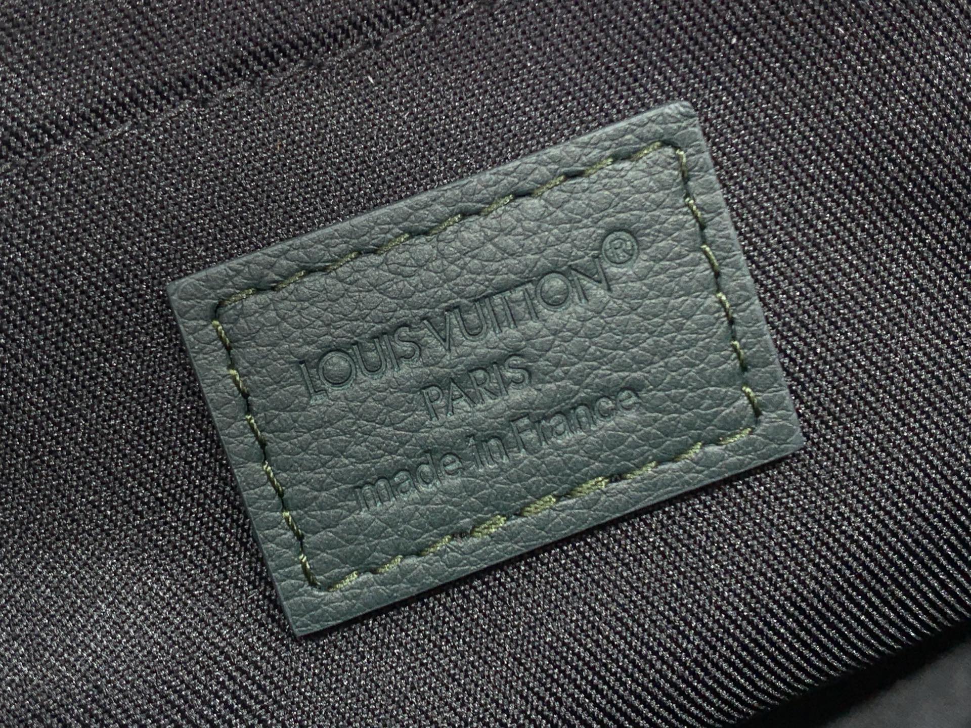 Louis Vuitton Paris leather logo patch with engraved text on dark fabric