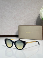 Bvlgari sunglasses with black round frames and yellow-green lenses, gold-tone temples