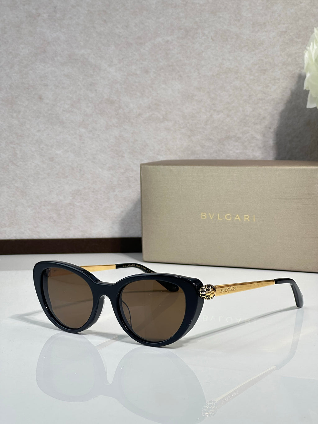 Bvlgari sunglasses with black rounded frames and dark lenses, gold-tone logo temples