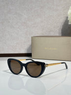 Bvlgari sunglasses with black rounded frames and dark lenses, gold-tone logo temples