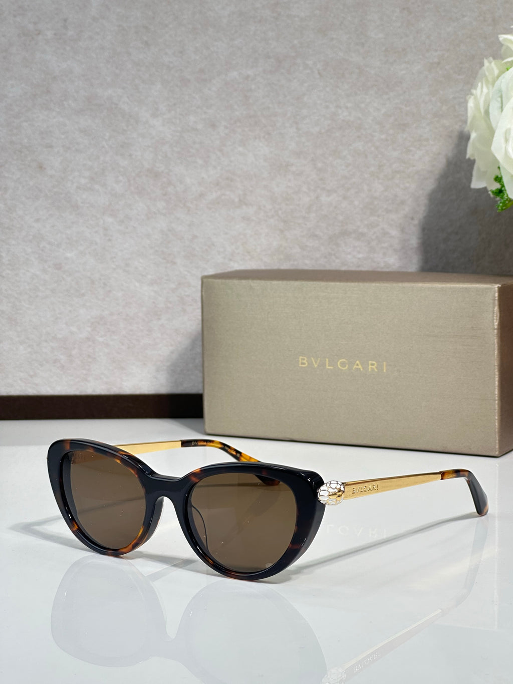 Bvlgari sunglasses with black round frames and brown-tinted lenses, gold-tone temples