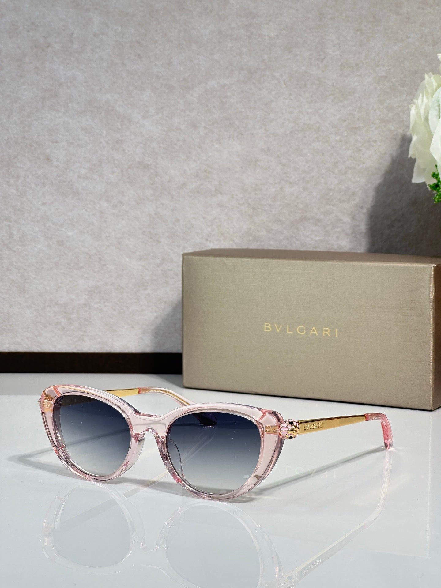 Bvlgari sunglasses with pink translucent round frames and dark lenses, gold-tone temples