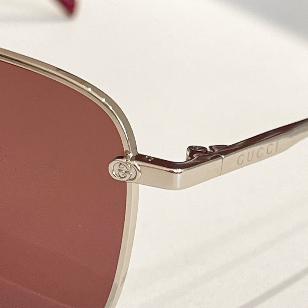 Gucci sunglasses close-up of gold temple with circular logo emblem