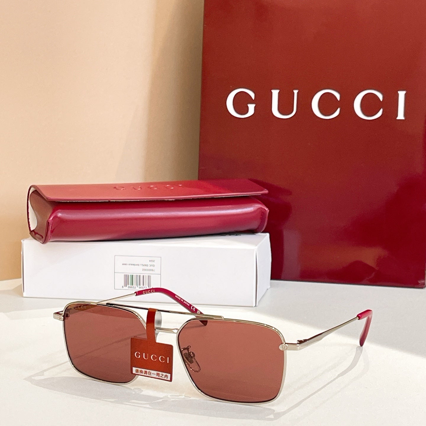 Gucci sunglasses with gold frame and brown red tinted lenses, slim metal arms