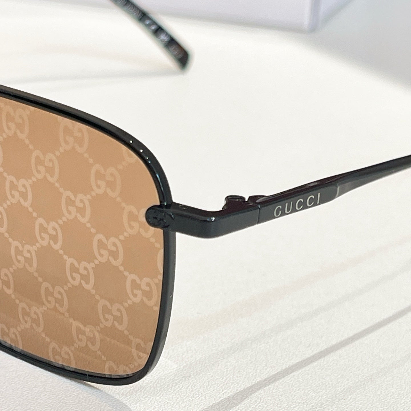 Black rectangular eyeglass frame with brown lenses and side logo
