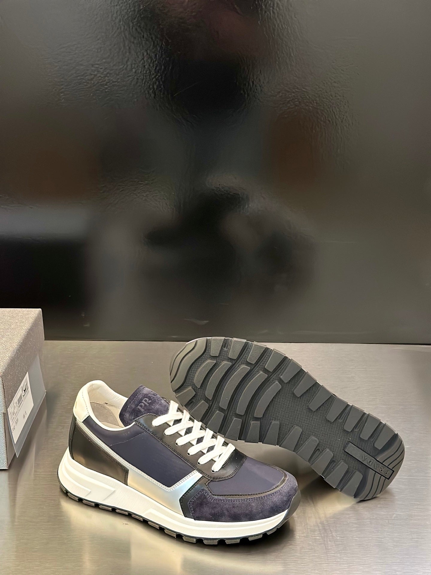 Prada unisex sneakers with visible tread outsole, navy upper and cream sole