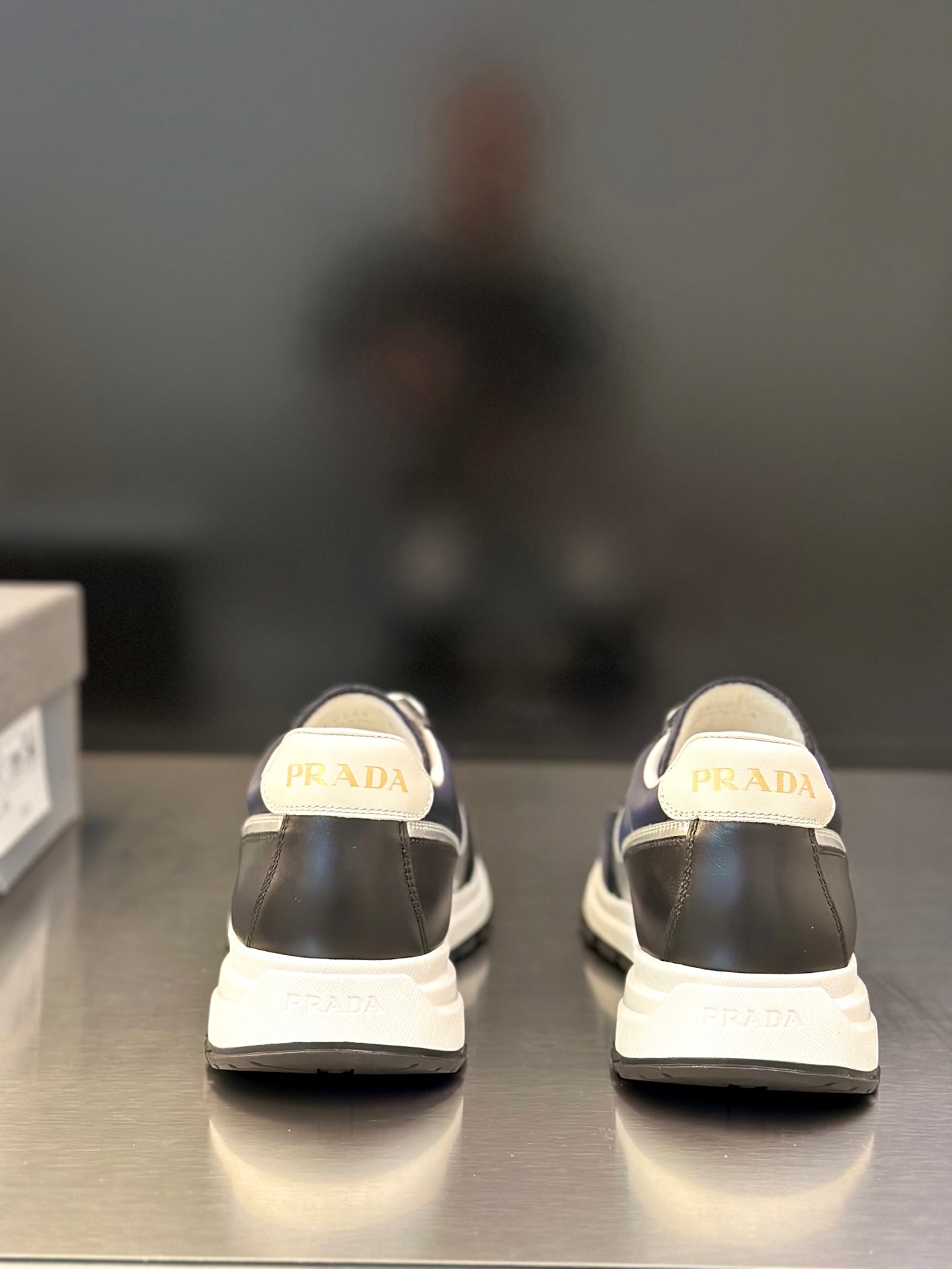 Prada unisex sneakers, rear view with PRADA logo on heel, dark navy