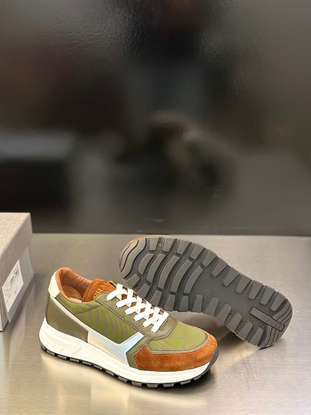Prada unisex sneakers with outsole tread visible; olive green, brown suede, white midsole
