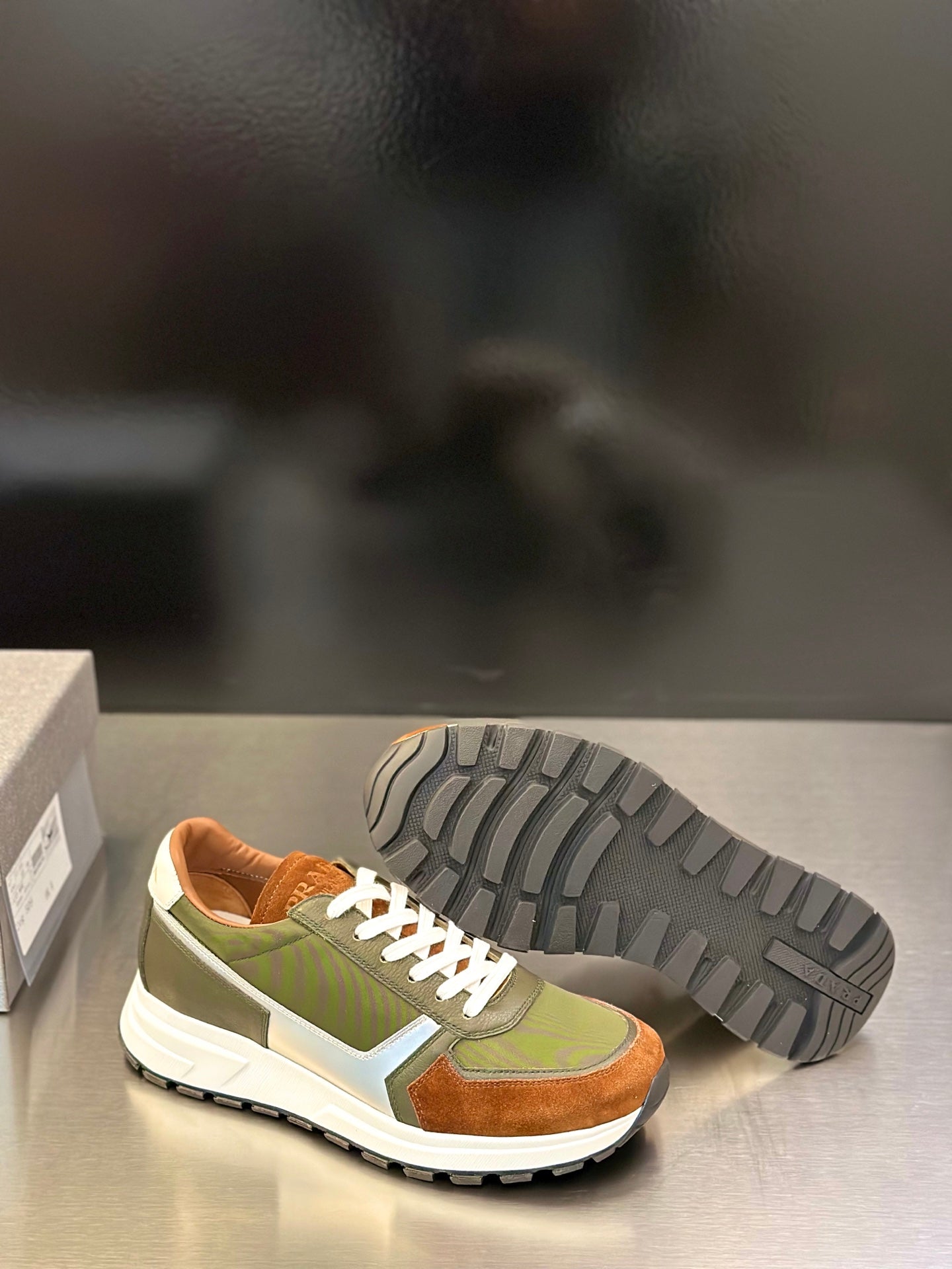 Prada unisex sneakers with outsole tread visible; olive green, brown suede, white midsole