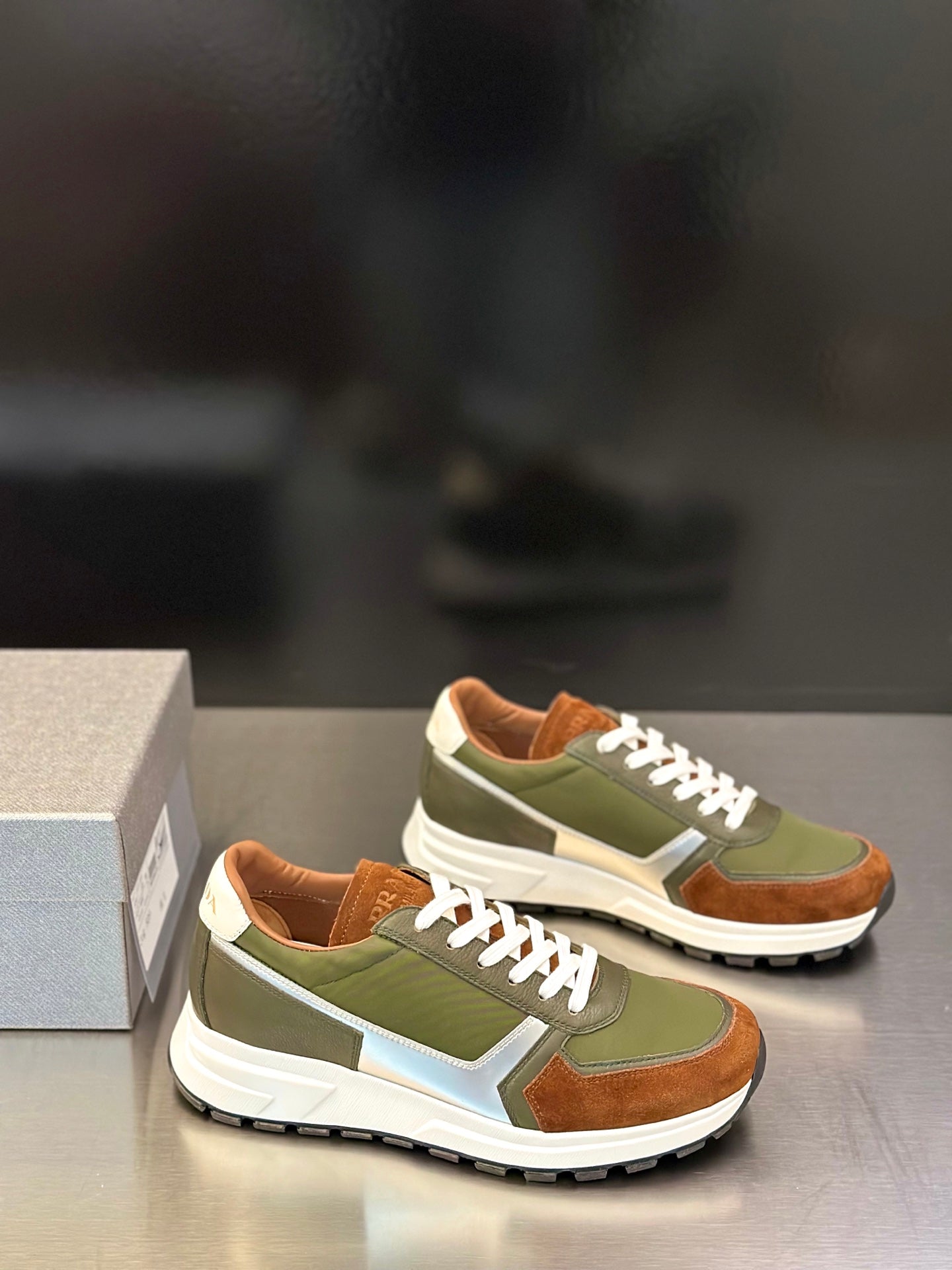 Prada unisex sneakers, side view, olive green and brown uppers with white laces