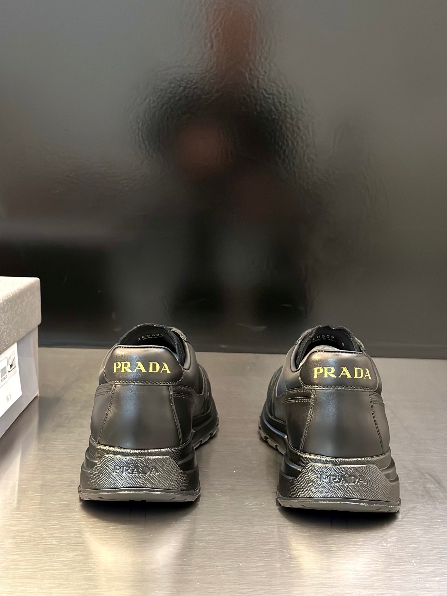Prada unisex lace-up sneakers, dark gray; rear view with PRADA branding on heel