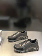 Prada unisex lace-up sneakers, gray with dark accents; side-by-side view and tread sole