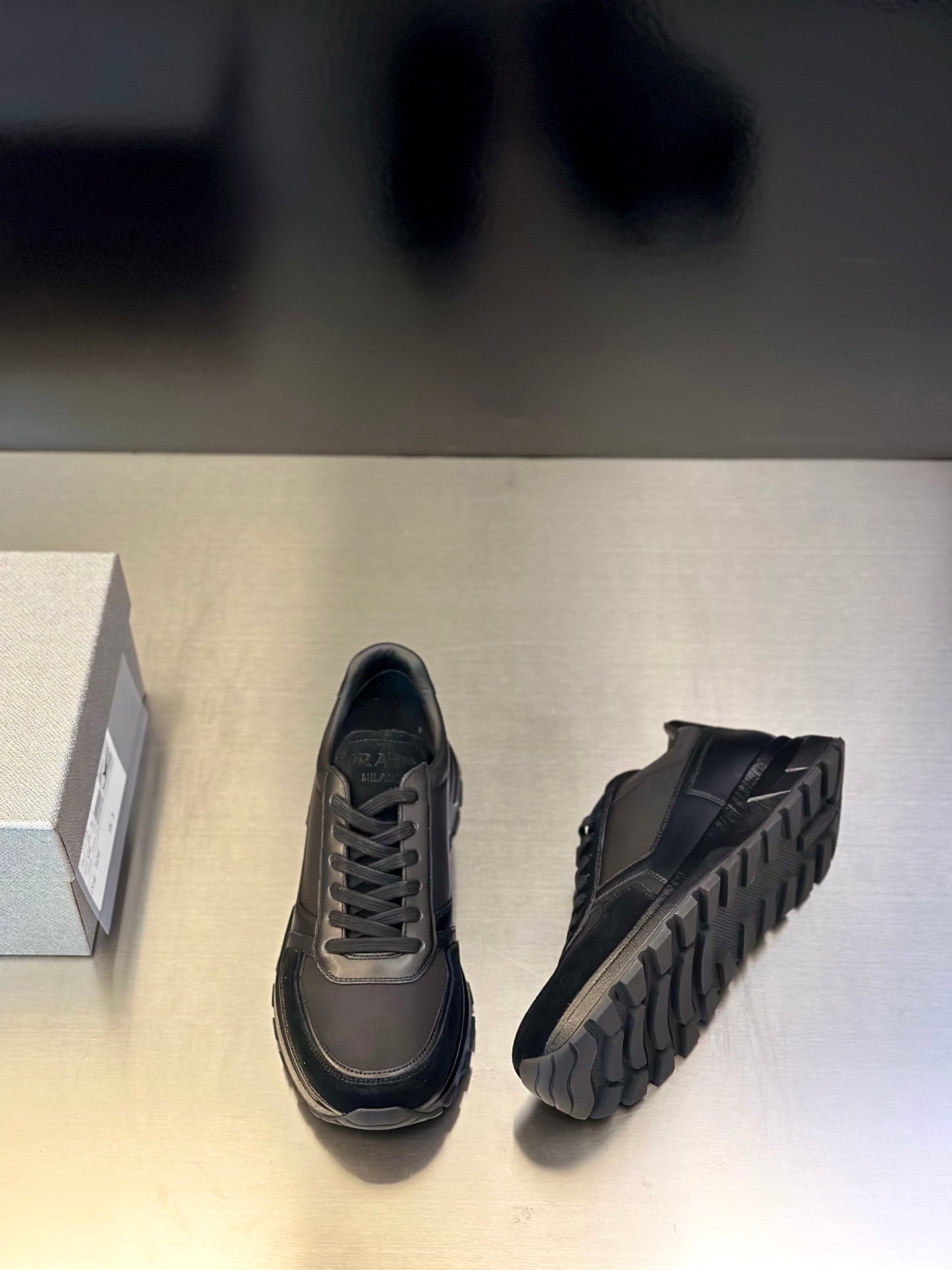 Prada unisex lace-up sneakers, dark gray; side view with textured rubber sole tread