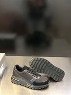 Prada unisex lace-up sneakers, metallic gray with black toe and visible tread outsole