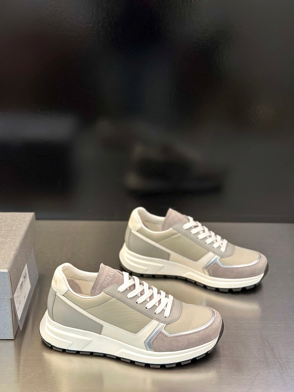Prada unisex sneakers pair in light gray-beige with white lace-up design