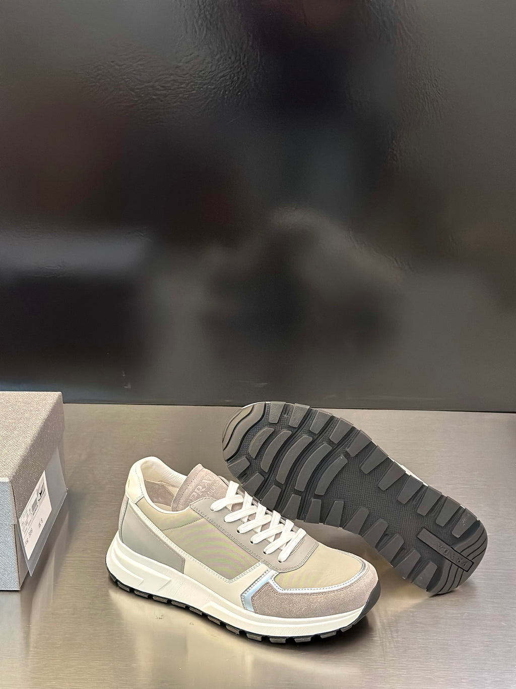 Prada unisex sneakers showing treaded rubber outsole and white lace-up upper