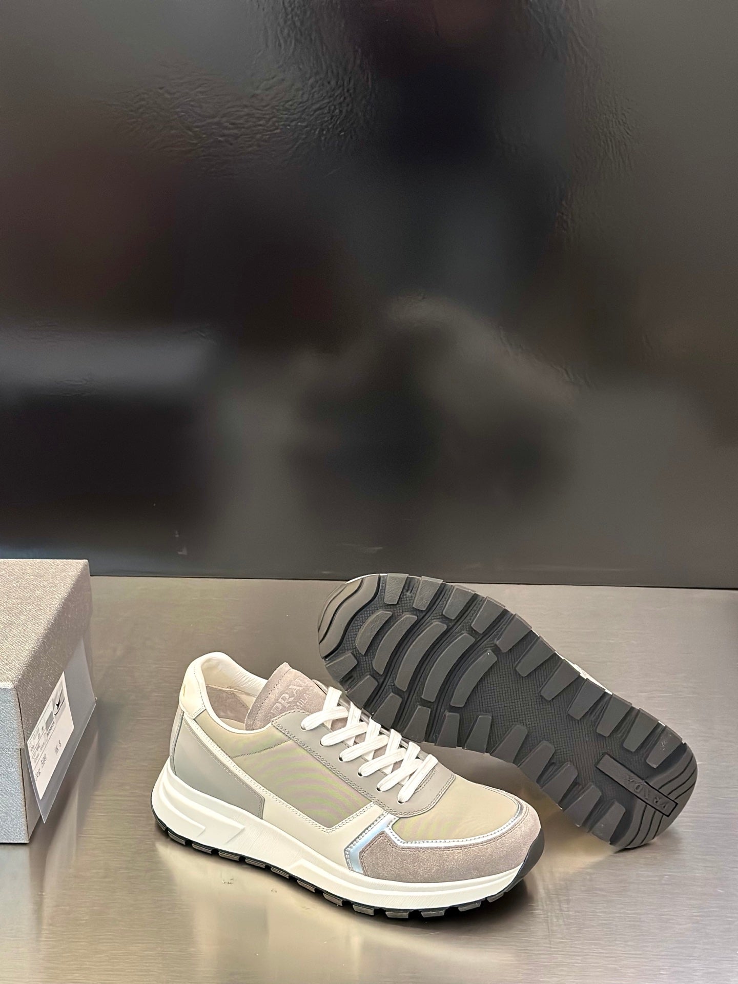 Prada unisex sneakers showing treaded rubber outsole and white lace-up upper