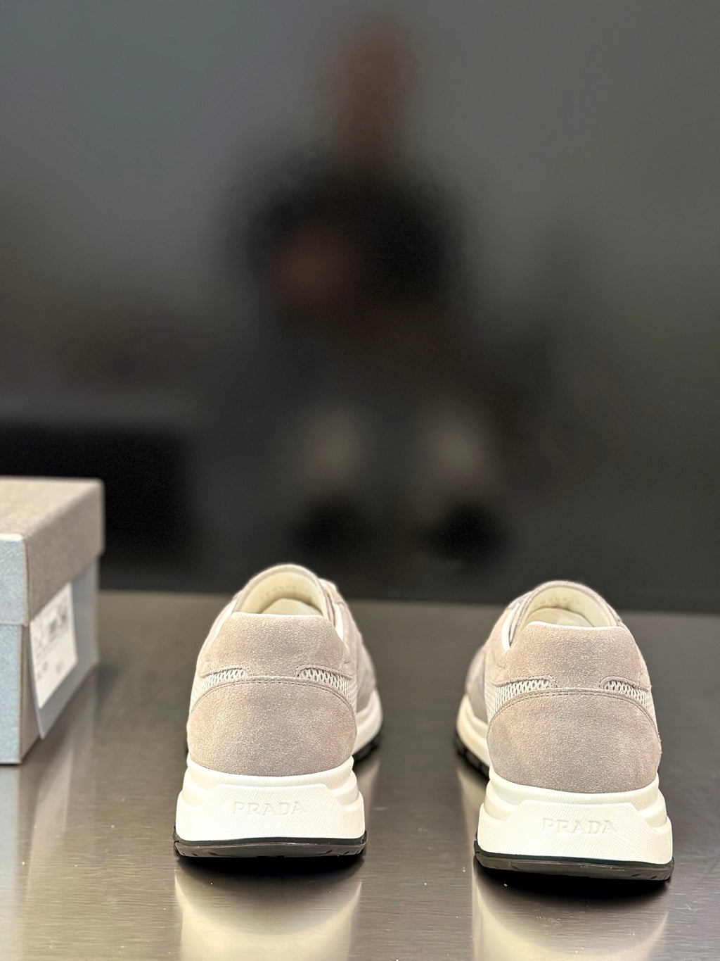 Prada unisex sneakers heel view, light gray suede upper, PRADA logo on back