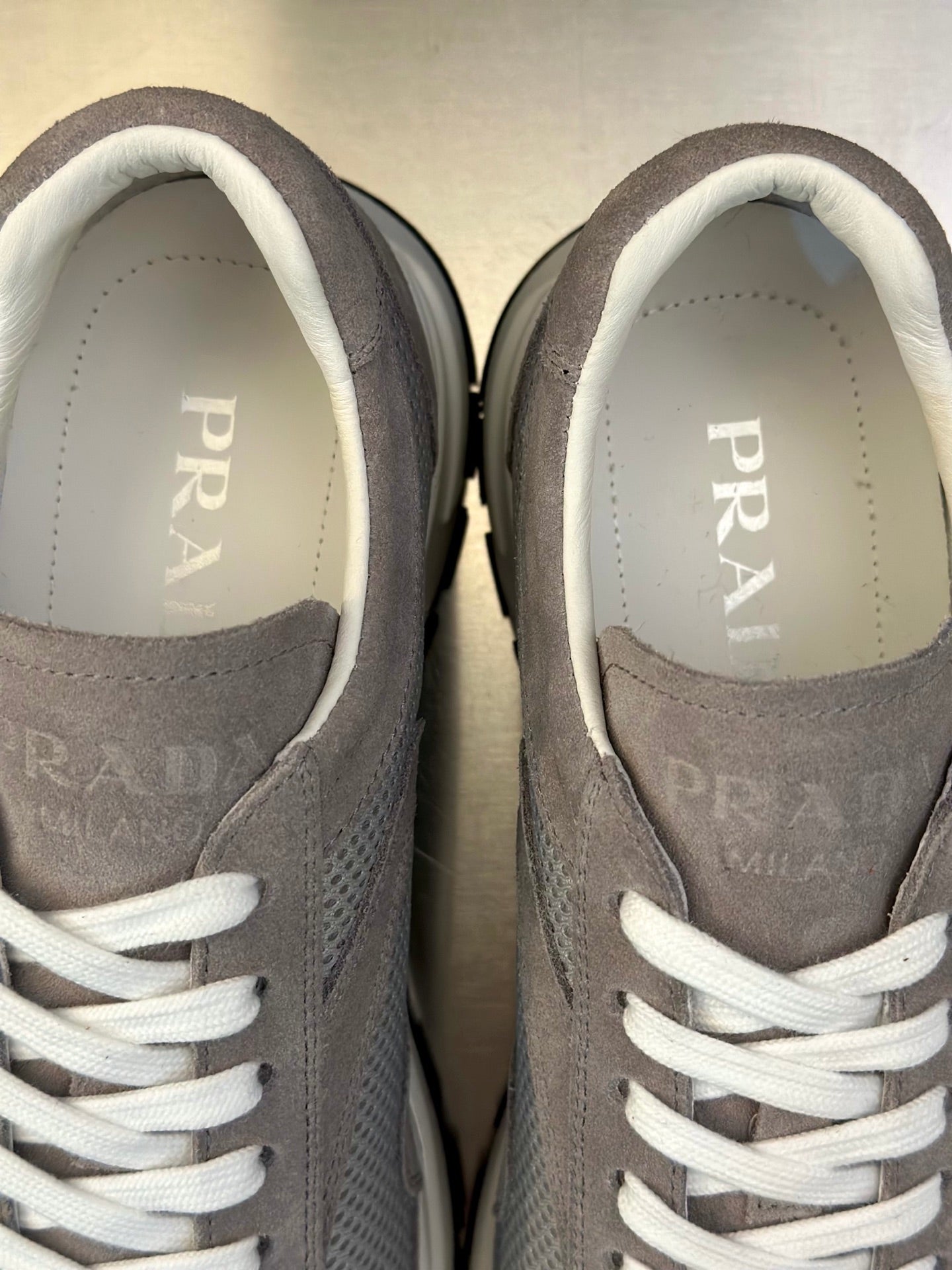 Prada unisex sneaker inner view, light gray suede with white laces and PRADA logo