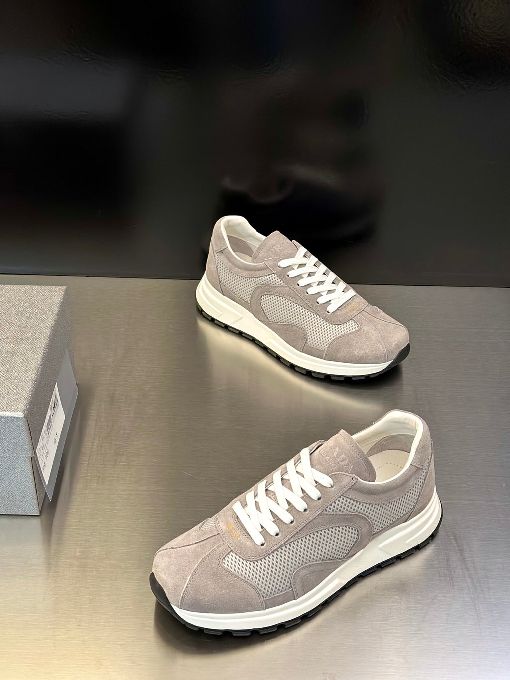 Prada unisex sneakers, light gray upper with white lace-up front, street-style profile