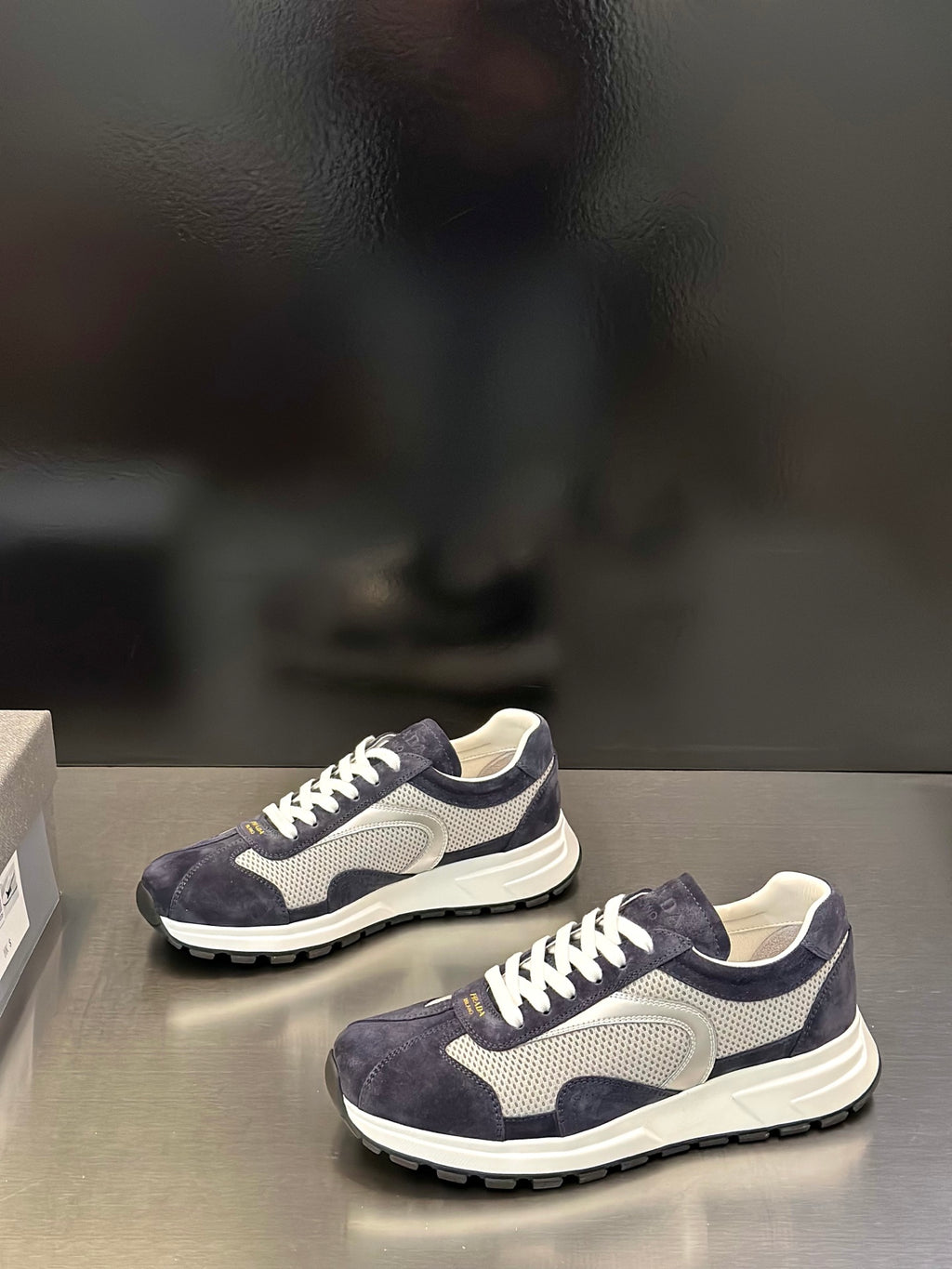 Prada unisex sneakers side view, navy suede upper with white laces and thick sole
