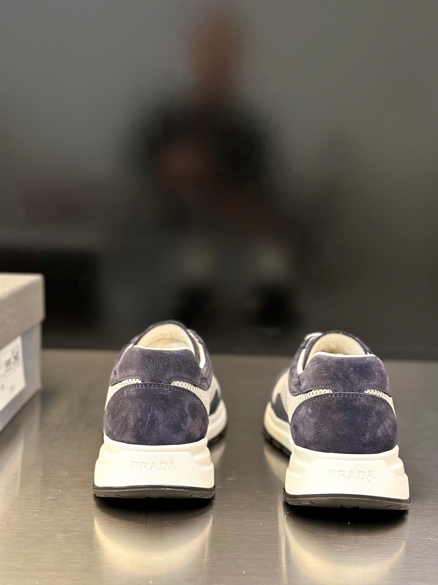 Prada unisex sneakers rear view, dark navy suede and white cushioned sole