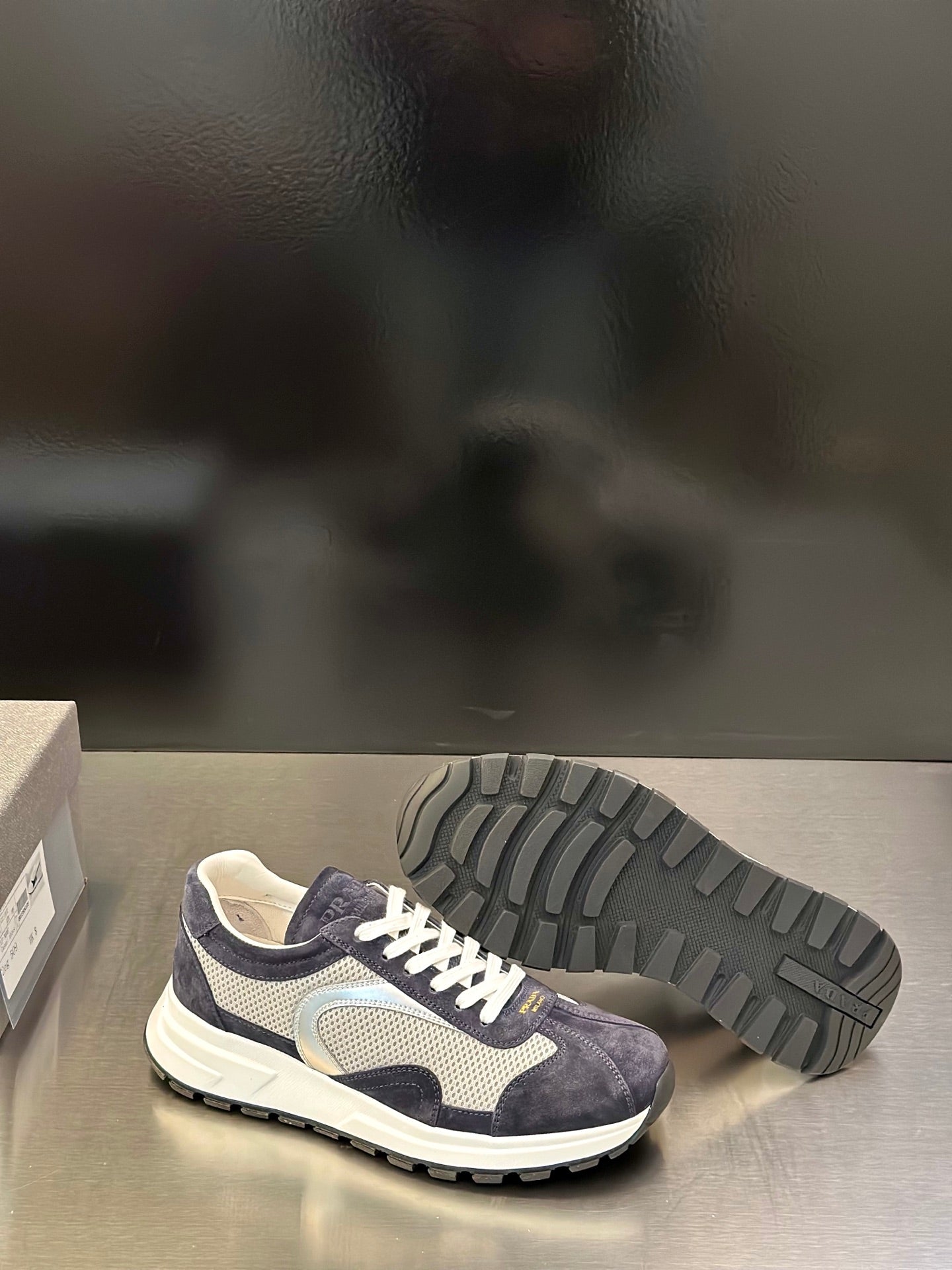 Prada unisex sneakers outsole view, dark navy upper with white laces and tread sole