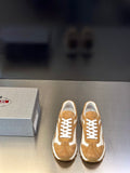 Tan suede sneakers with white panels, lace-up front, chunky rubber sole