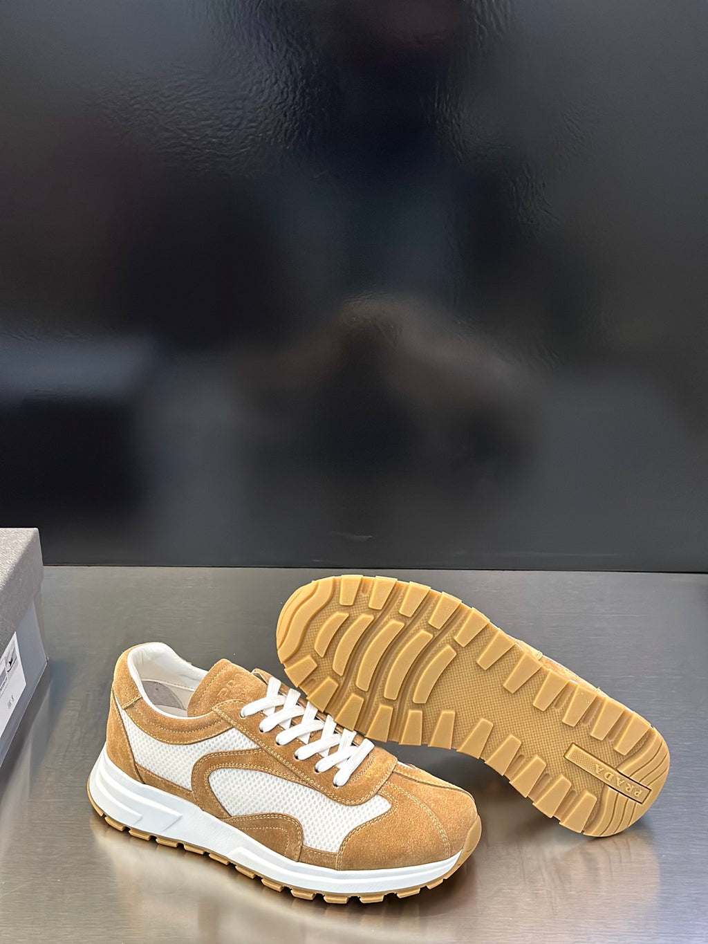 Tan sneakers shown with outsole tread on rubber sole, lace-up style