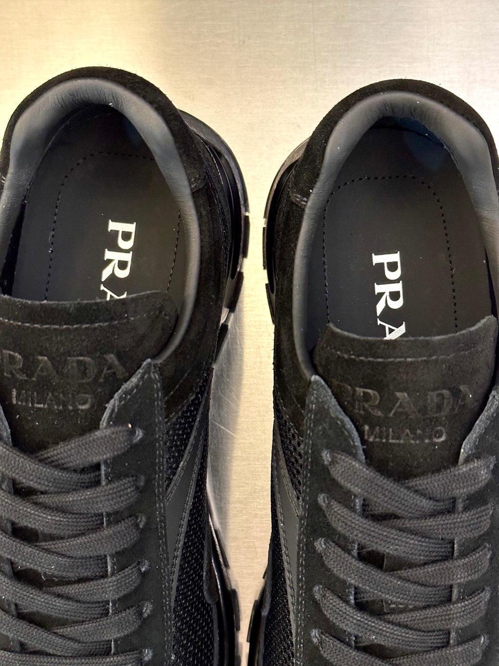 Prada unisex sneaker close-up, PRADA logo on tongue and laced upper