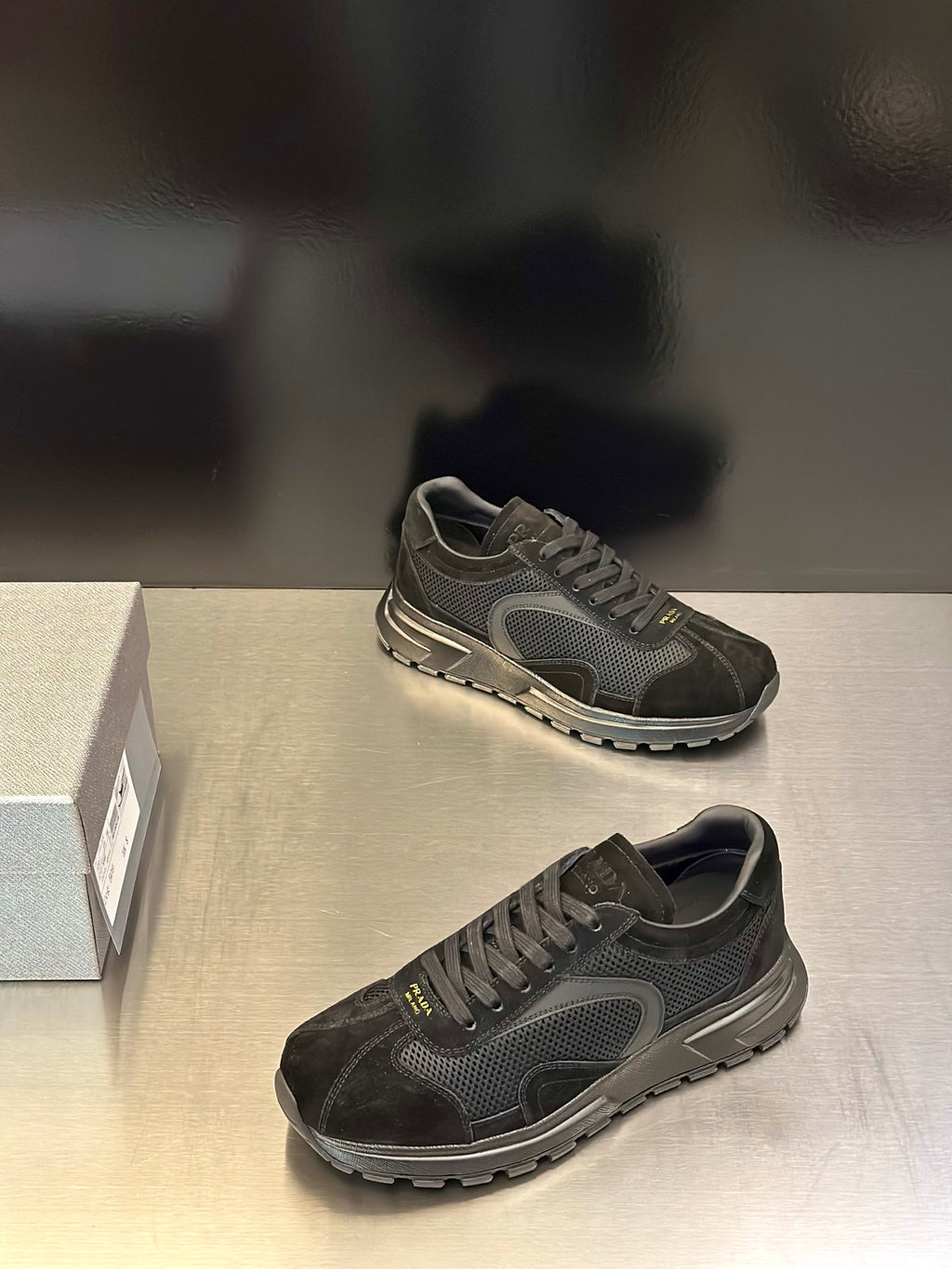Prada unisex dark lace-up sneakers with textured panels and treaded outsole