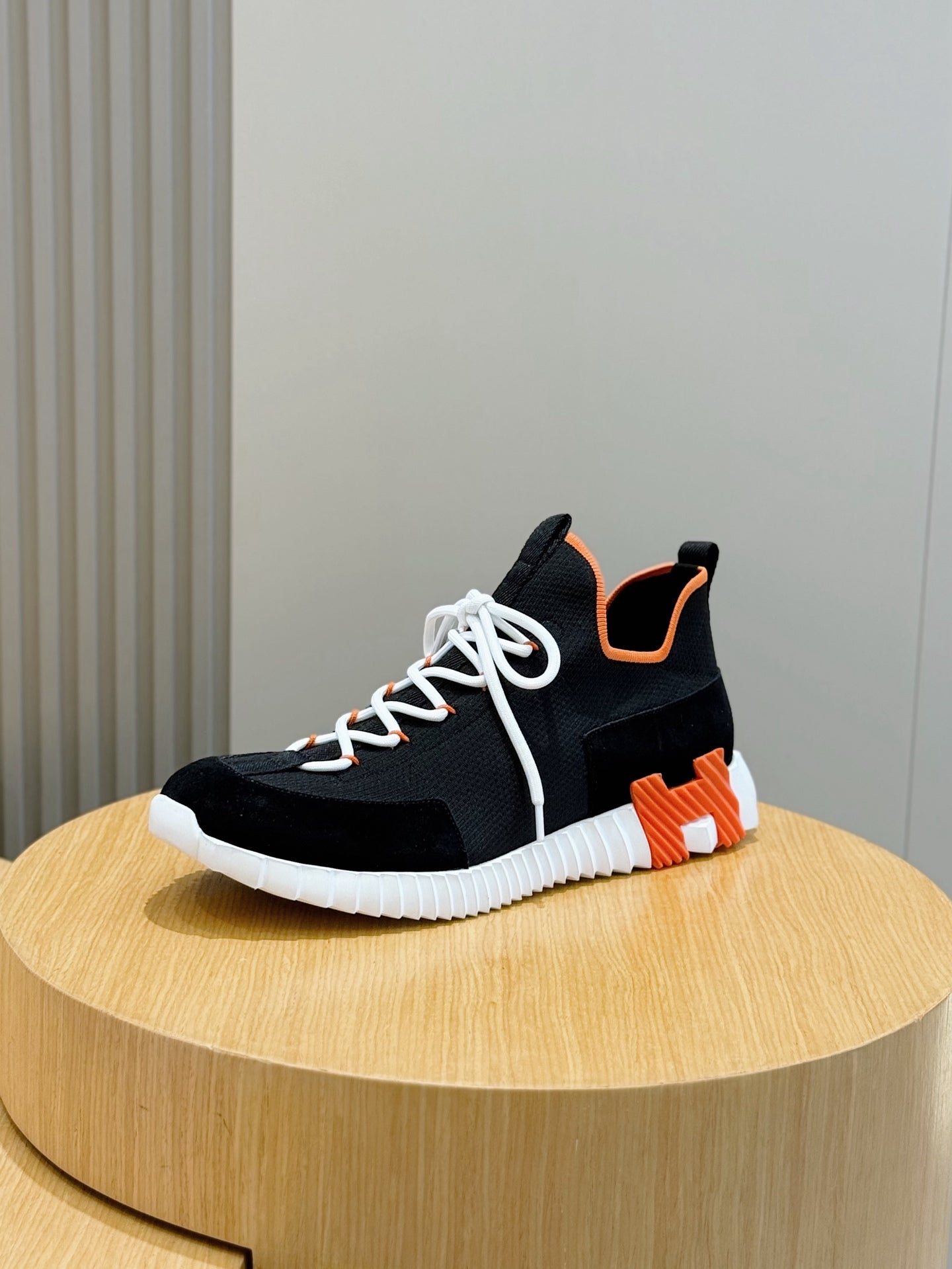 Hermes unisex sneakers, black upper with orange heel tab and white laces, white ribbed sole