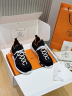 Hermes unisex sneakers, black knit with orange trim, white laces and chunky white sole