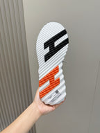 Hermes unisex sneakers outsole, black-and-orange striped tread on white rubber sole