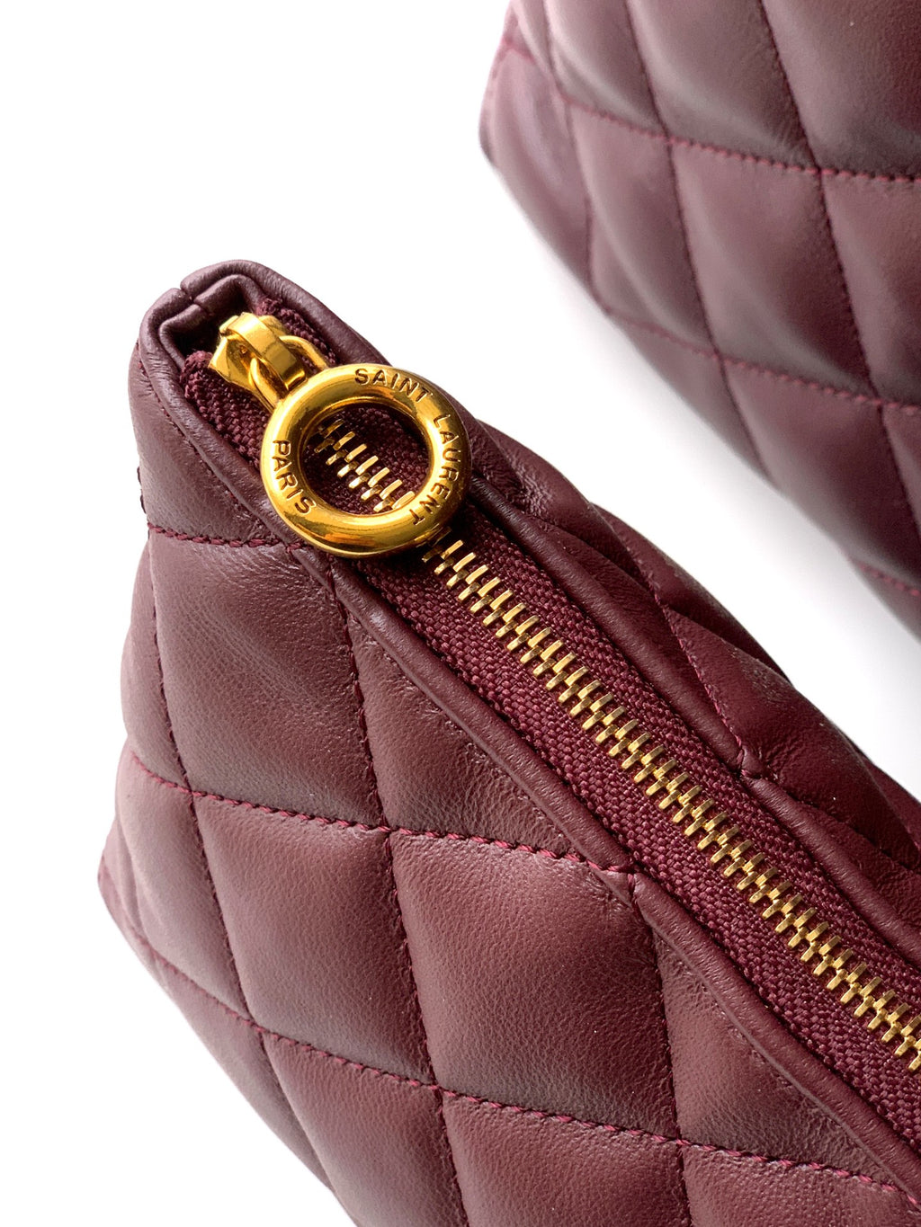 YSL quilted zipper pull in gold on burgundy leather bag