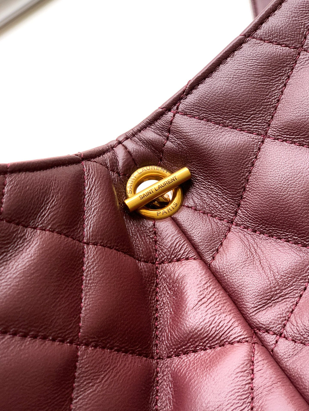 YSL quilted tote handle detail with gold hardware snap, burgundy leather