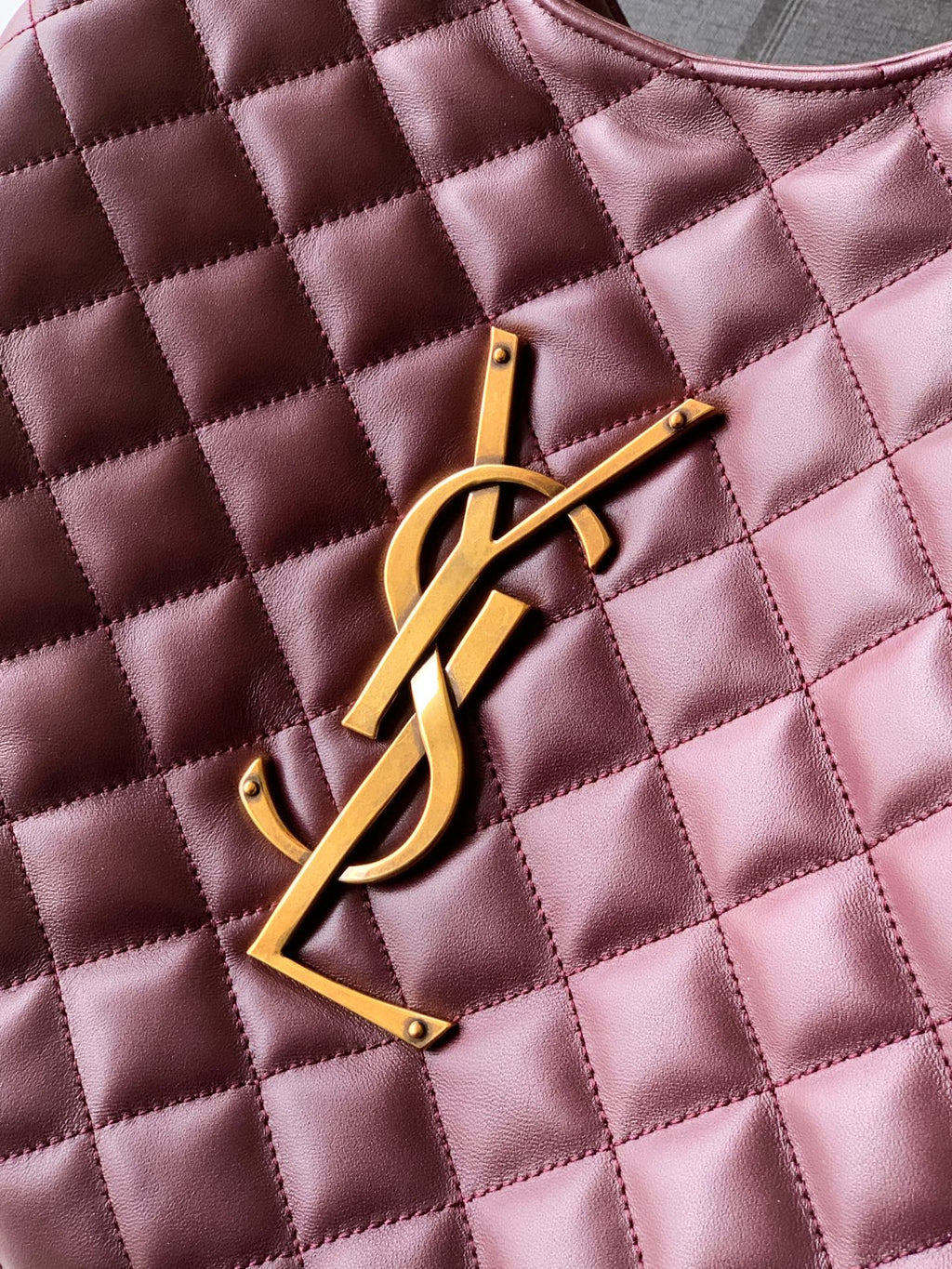 YSL gold logo emblem on quilted burgundy leather