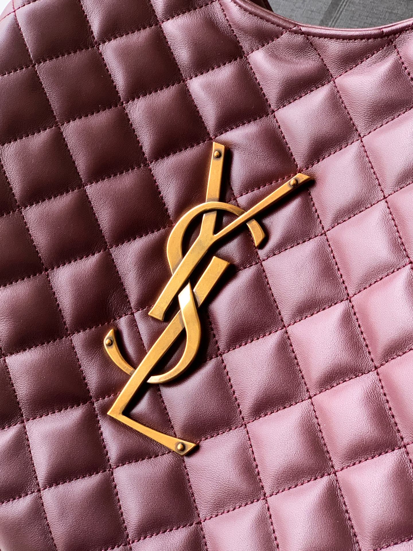 YSL gold logo emblem on quilted burgundy leather