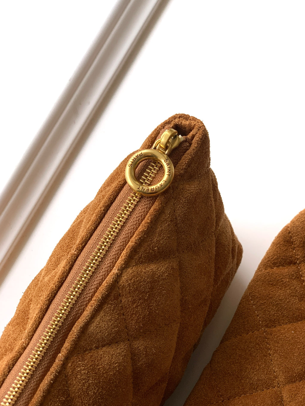 YSL bag close-up of tan suede zipper with gold ring pull